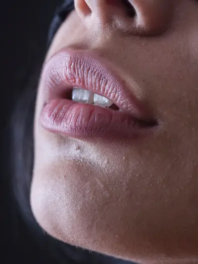 Close-up of full, natural lips in low light