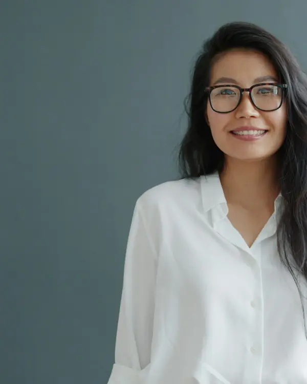 Portrait of a smiling woman doctor in glasses and a white shirt